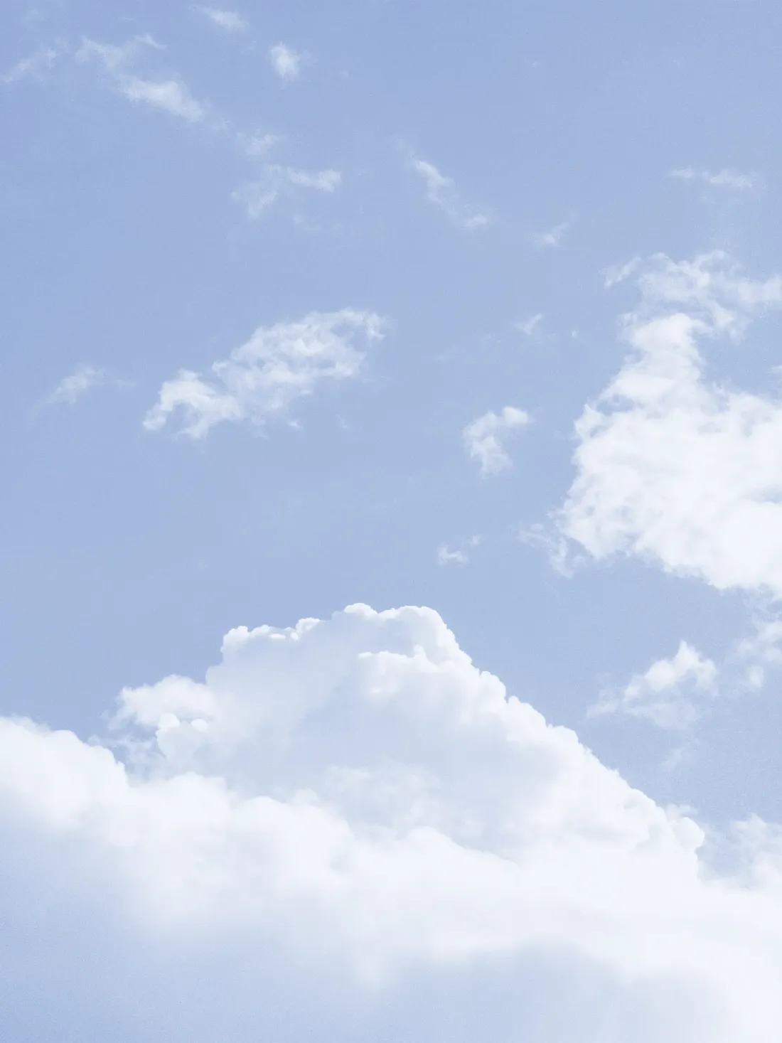 Soft cumulus clouds in a light blue sky